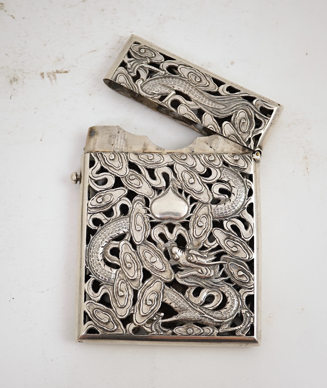 A late 19th century Chinese Export pierced silver card case, maker KMS(Kwong Man Shing), decorated with dragons amid clouds, 10.4cm, together with a Chinese Export pierced silver octagonal box and cover, by Luen Wo?, cir